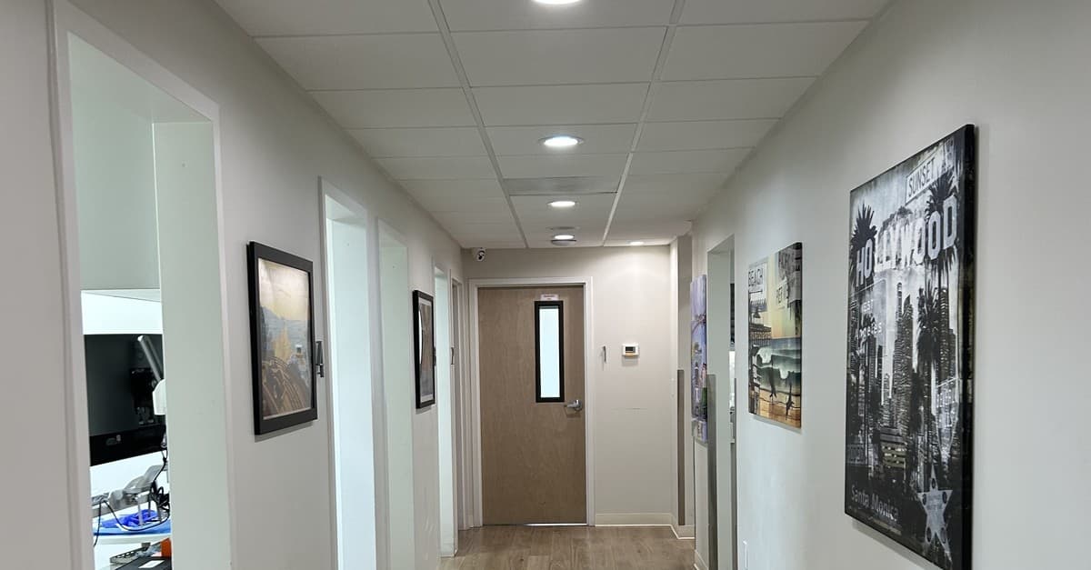 A bright hallway at Lotus Dental Group in San Jose with multiple treatment rooms opening off one corridor